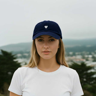 Navy blue cotton baseball cap with a white heart emblem embroidered by Atticus Poetry 